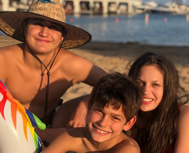 Mason Firestone 25 (bottom center), Cameron Firestone ‘21, and oldest brother Tyler Firestone (top left) at a beach in Harbor Springs, Michigan.