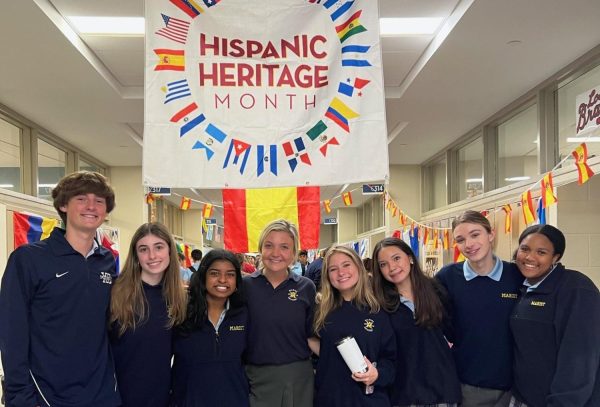 Members of the Spanish Club gather below the banner that welcomes everyone to the celebration.