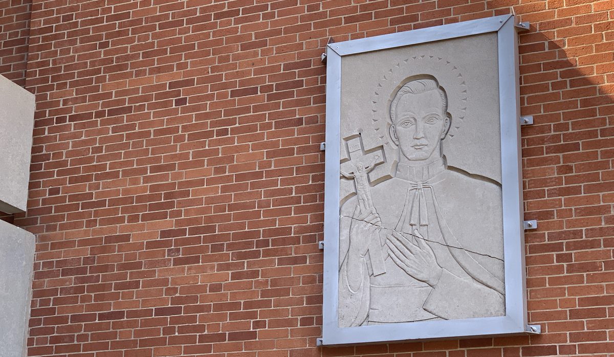 The stone engraving mounted to the side of Chanel Building traveled all the way from Bedford, Ohio, where it hung above the entrance of Saint Peter Chanel High School.