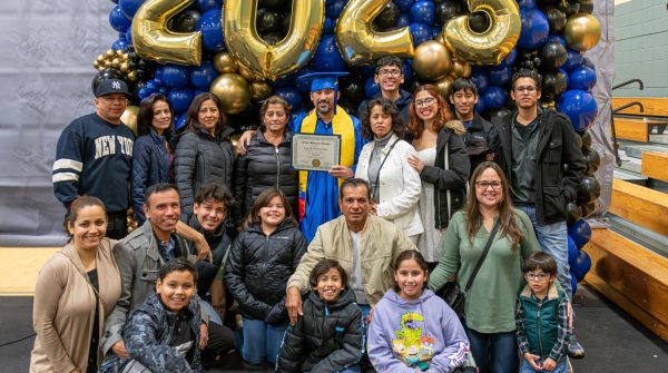 One Centro Hispano Marista family gathers around a recent graduate for a photo.