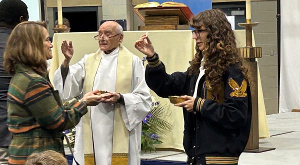 Sophia Ghavidel serves as a Eucharistic Minister during an all school Mass.