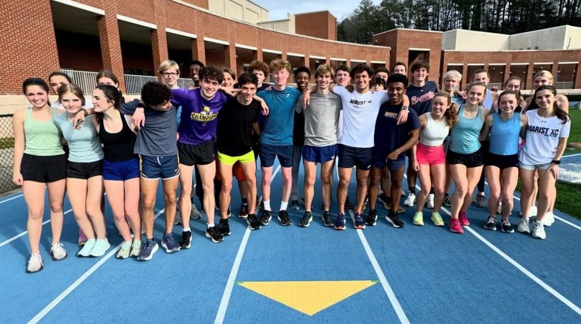Members+of+the+track+and+field+team+gather+on+the+track+next+to+Centennial+Center+for+a+photo.