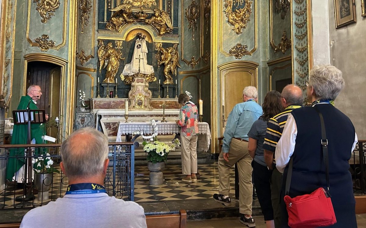 Father John Harhager looks on as pilgrims sign their own pledge to follow the Marist Way. Among the visitors were Board Chairman Mike Cote, Iris Chang, Jim MacGinnittie, Cristina Herrera, Carlos Herrera, and Sister Teri O’Brien.