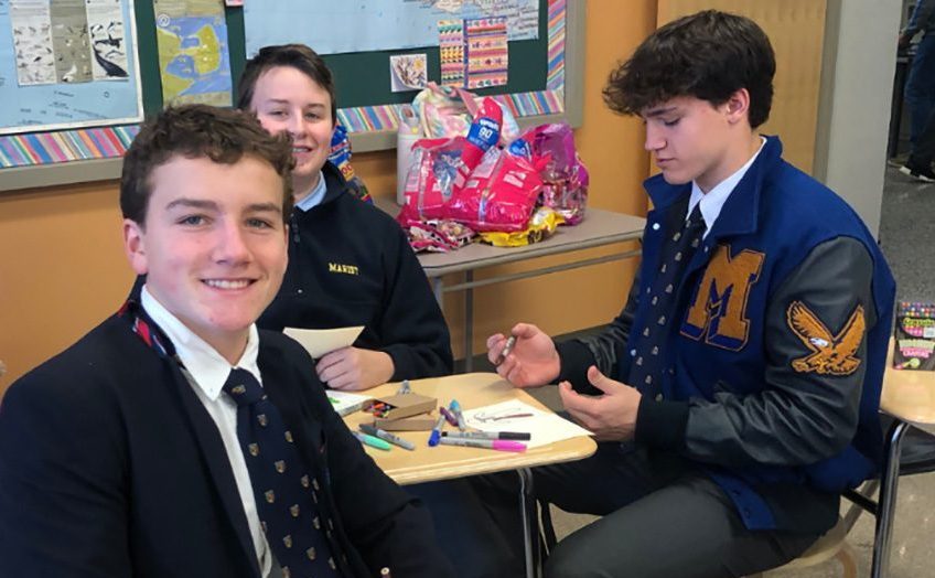 Hayes Rollauer, Griffin Heard, and Jack Simmons devote some time during activity period to write holiday greetings to the students of Berkeley Lake Elementary School . 