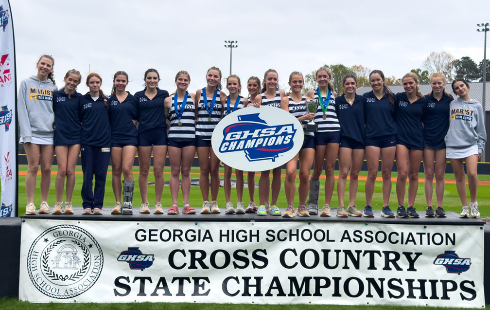 The girls cross country team gather to record their historic, state championship victory. (Contributed to The Blue & Gold)