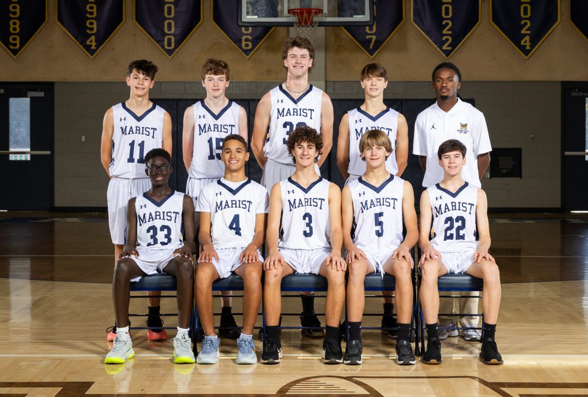 The nine members of the 9th grade boys basketball team pose for a team photo.